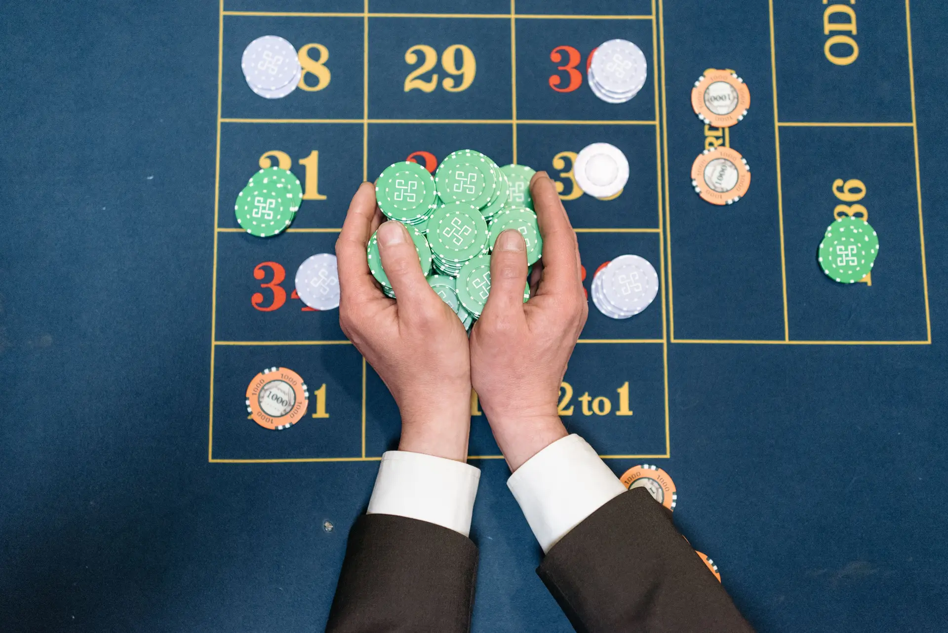 Hände mit Chips am Spieltisch